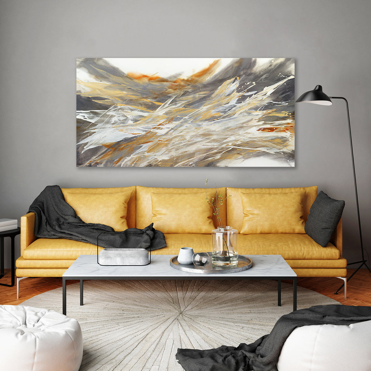 An orange, white, and black abstract painting by Teodora Guererra hangs on a wall above a cognac leather sofa .