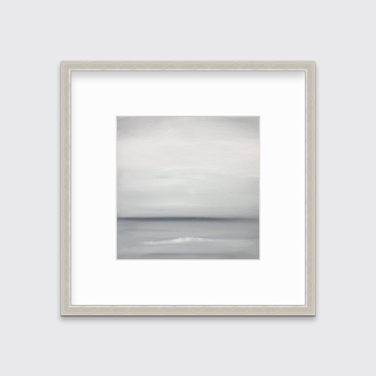 A tonal grey abstract print in a silver frame with a mat hangs on a white wall.