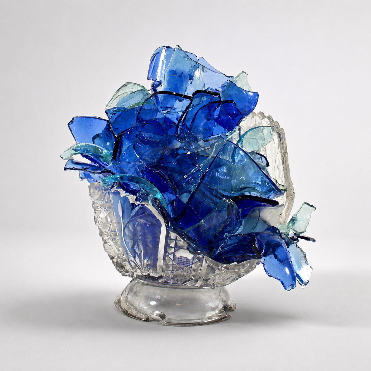 glass sculpture with blue and clear glass pieces on a white background