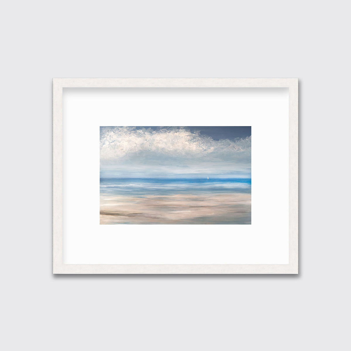 A blue, white and beige seascape print in a whitewashed frame with a mat hangs on a white wall.