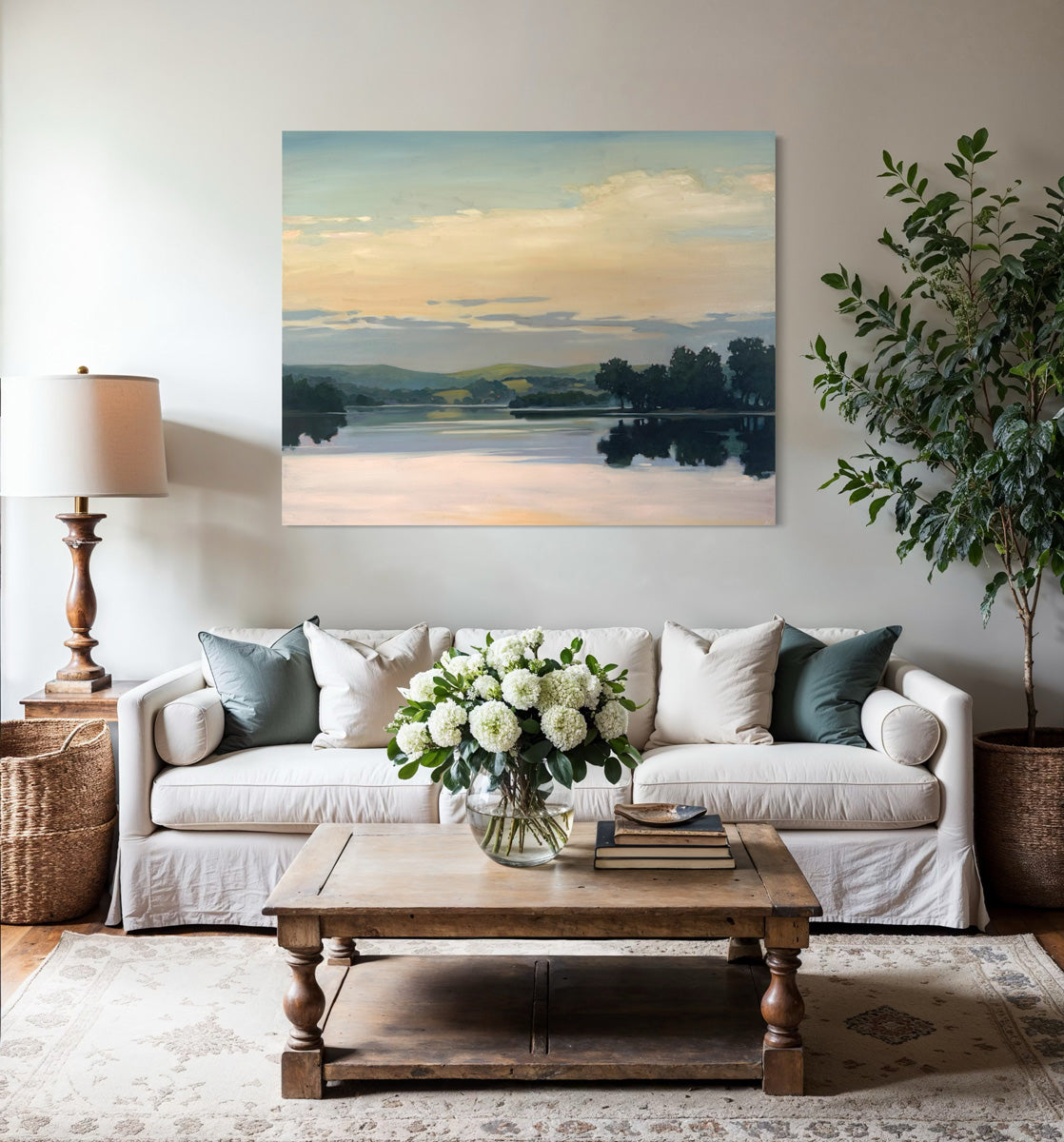 Living room with a sofa, coffee table, with an original landscape painting above the sofa.