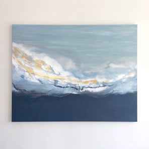 A blue, white and metallic gold abstract painting hangs on a white wall.