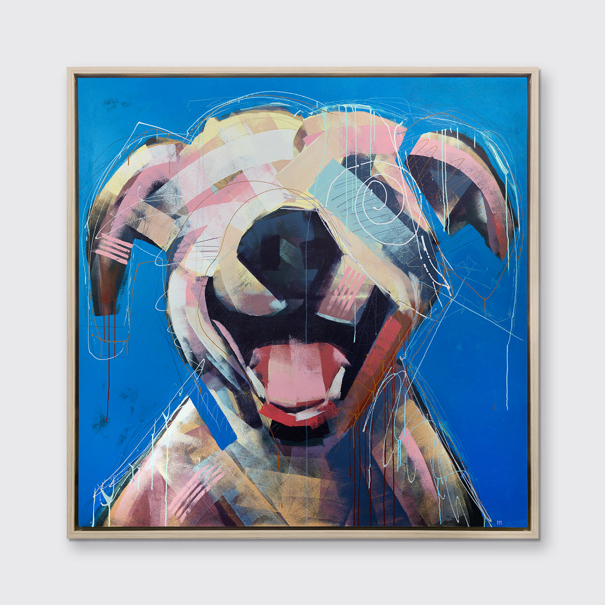 A yellow-orange, pink, red and blue abstract dog print in a white oak wood floater frame hangs on a white wall.