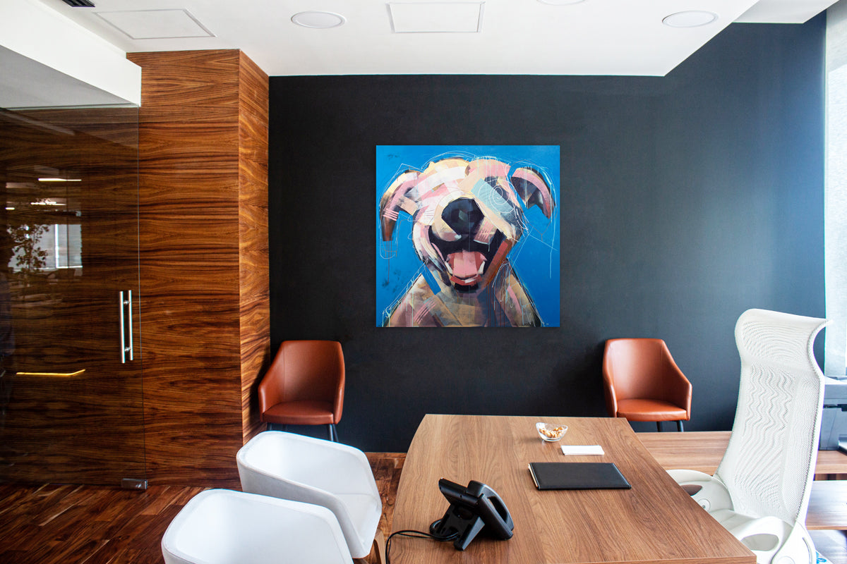 An abstracted painting of a dog hangs on a dark blue wall between two brown armchairs in a modern office space. 