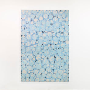 A white and blue abstract painting hangs on a white wall. 