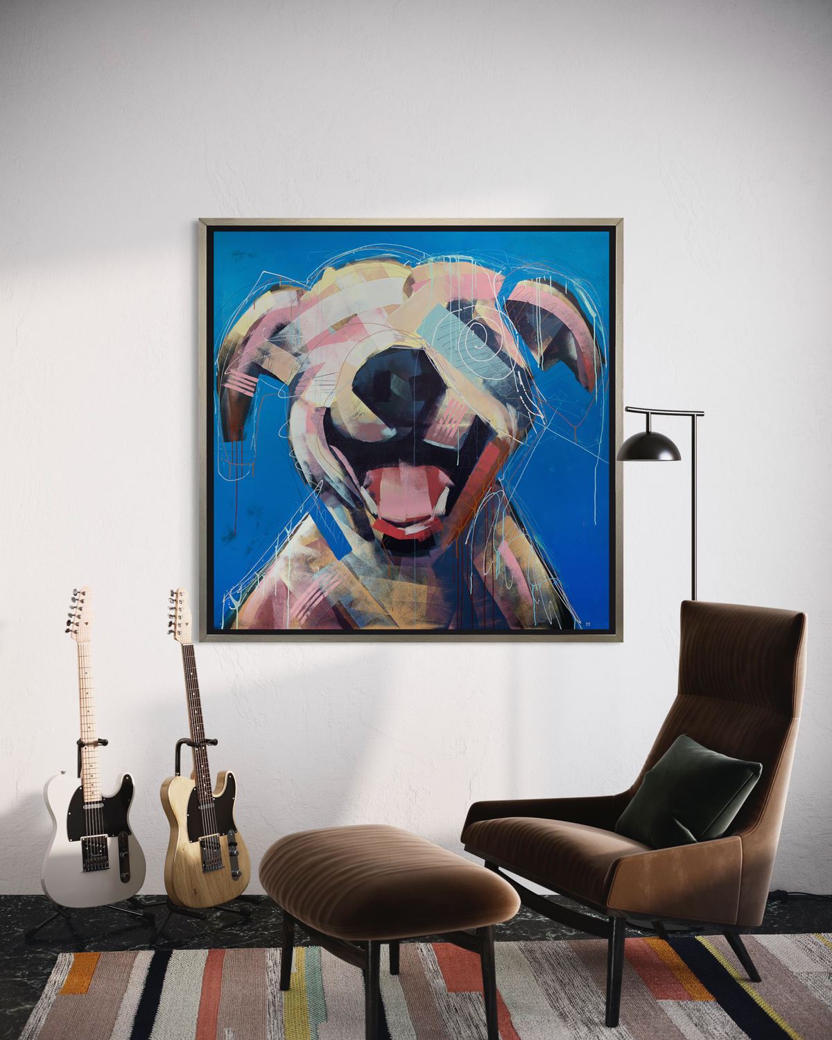 A yellow-orange, pink, red and blue abstract dog print in a silver floater frame hangs on a white wall above a brown lounge chair with matching ottoman, a thin black floor lamp and two guitars in stands.