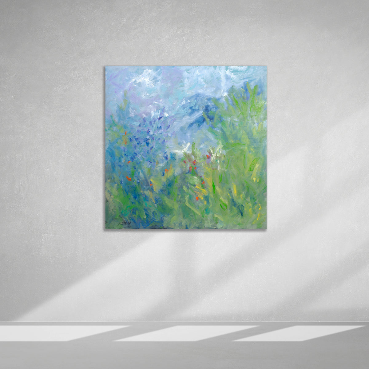 Abstract floral painting with blue and green hues on a gray wall