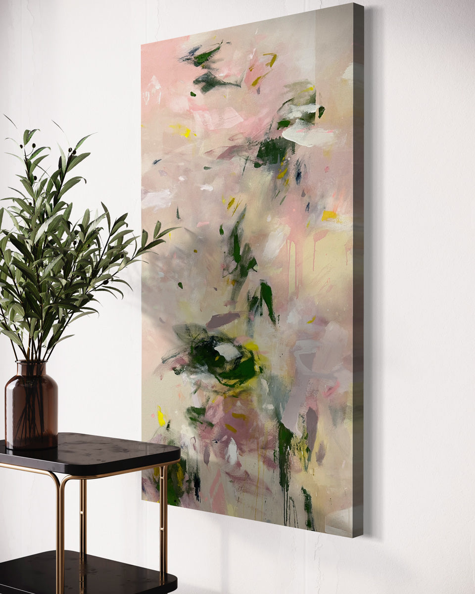 A pink and green abstract painting hangs on a white wall behind a black and brass bar cart with a plant in a glass vase. 