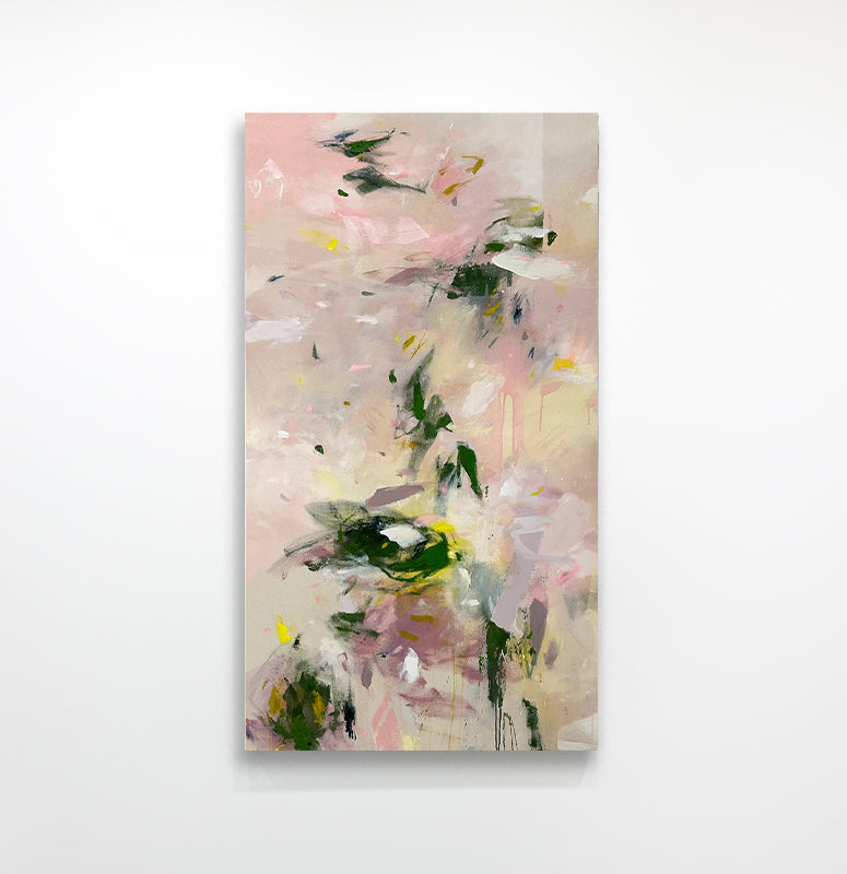 A pink and green abstract painting hangs on a white wall. 
