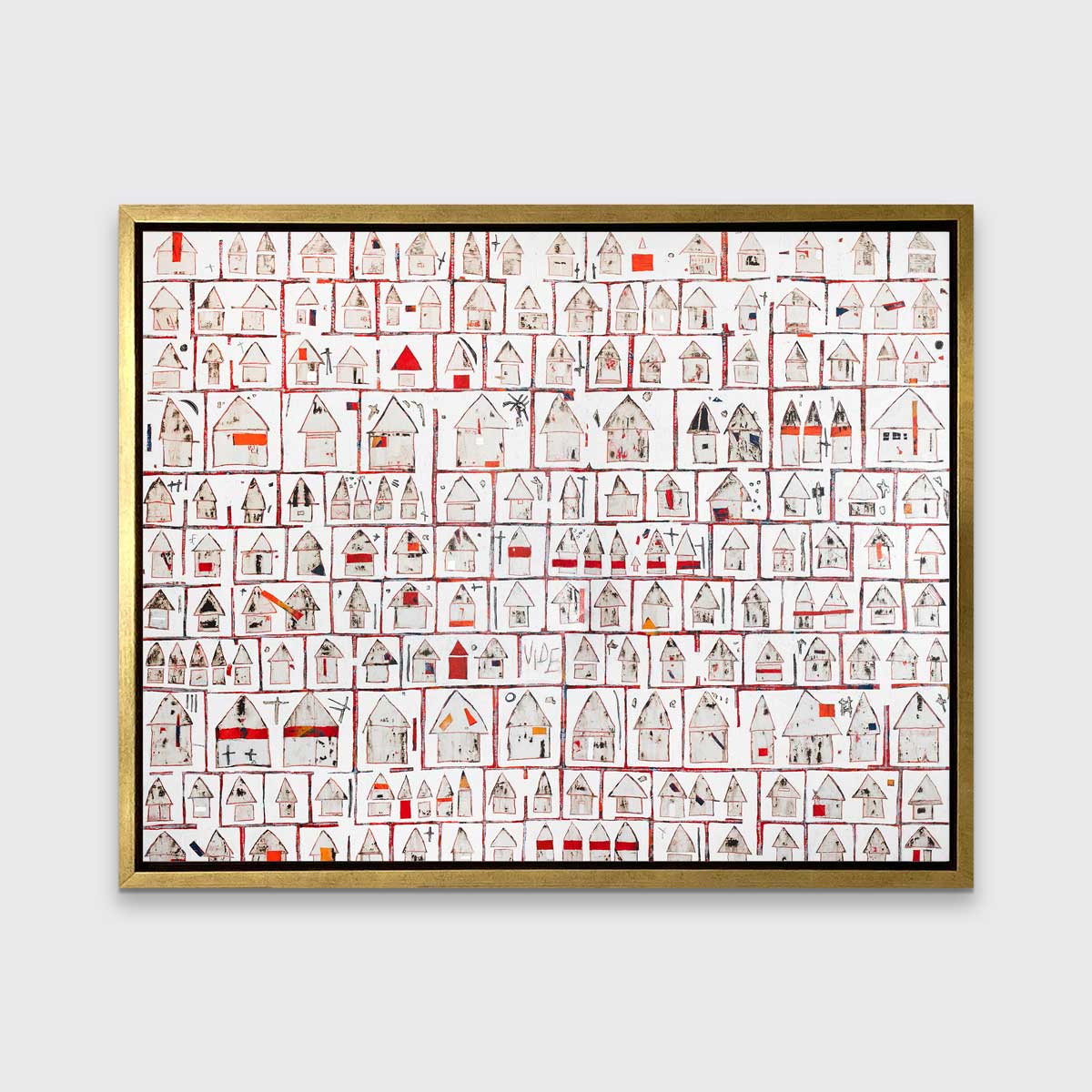 A red and white abstract house print in a gold floater frame hangs on a white wall.
