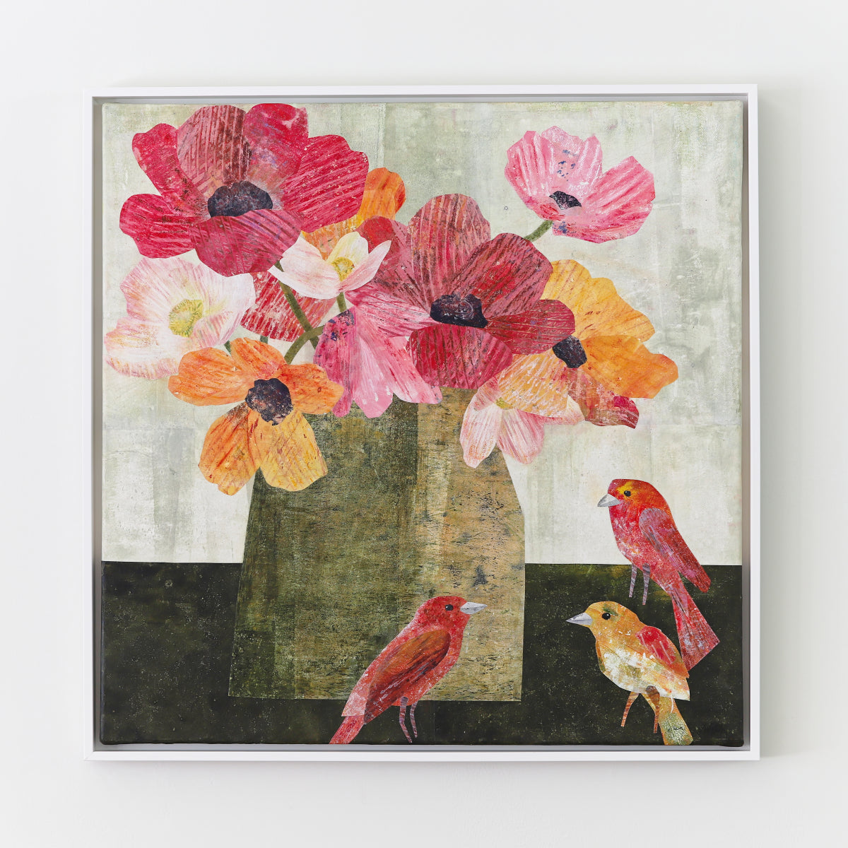A framed square collage featuring a stylized still life of red, pink, orange, and yellow flowers in a vase with three small birds, shown against a light wall.