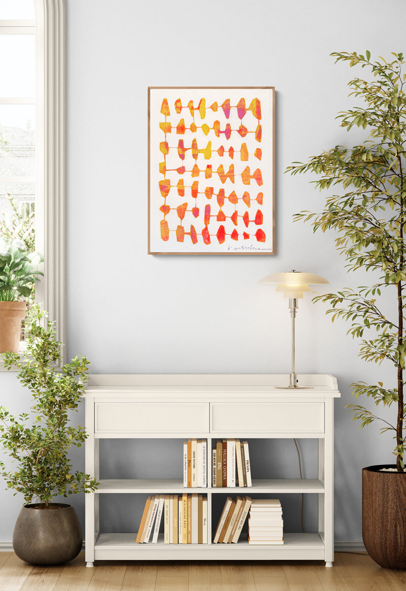 Modern interior with a white console table, books, and a colorful abstract painting on a light gray wall.