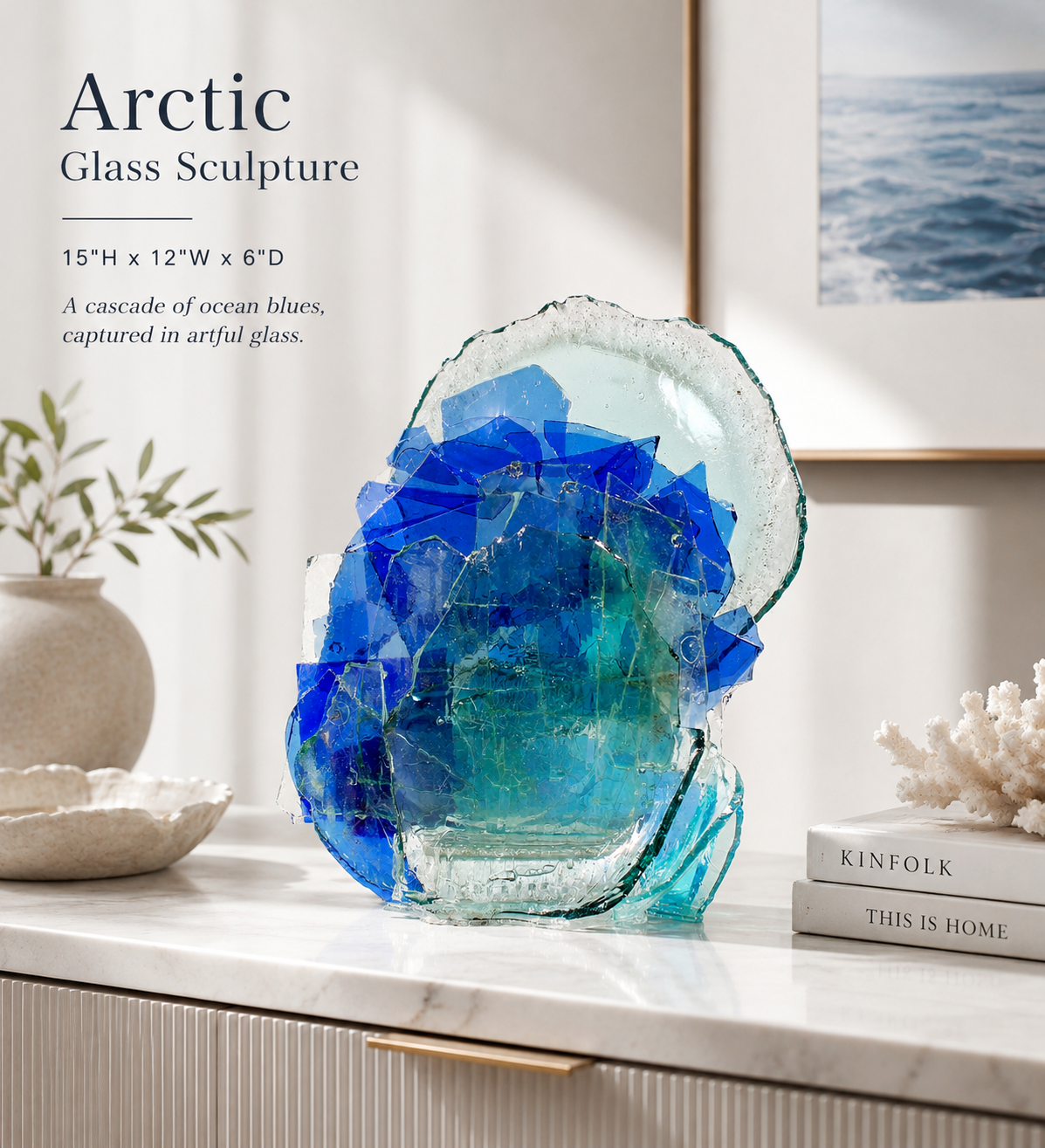 Glass sculpture with blue and green hues on a shelf with decorative books and a plant in a modern interior setting.