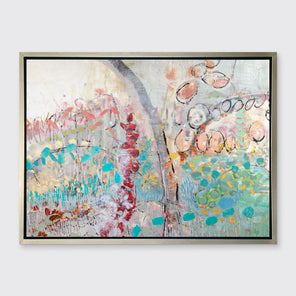 A multicolored abstract floral print in a silver floater frame hangs on a white wall.