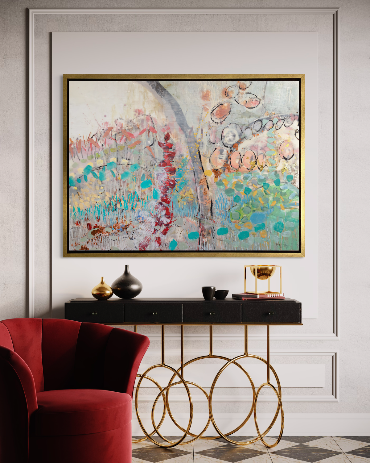 A multicolored abstract floral print in a gold floater frame hangs on a white wall above a contemporary black and gold console table with decorative accessories and a dark red velvet armchair.