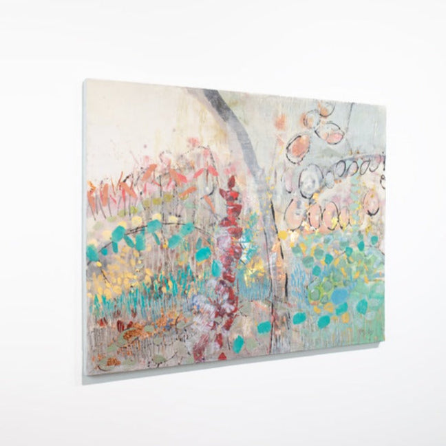 An abstract multicolored painting hangs on a white wall.
