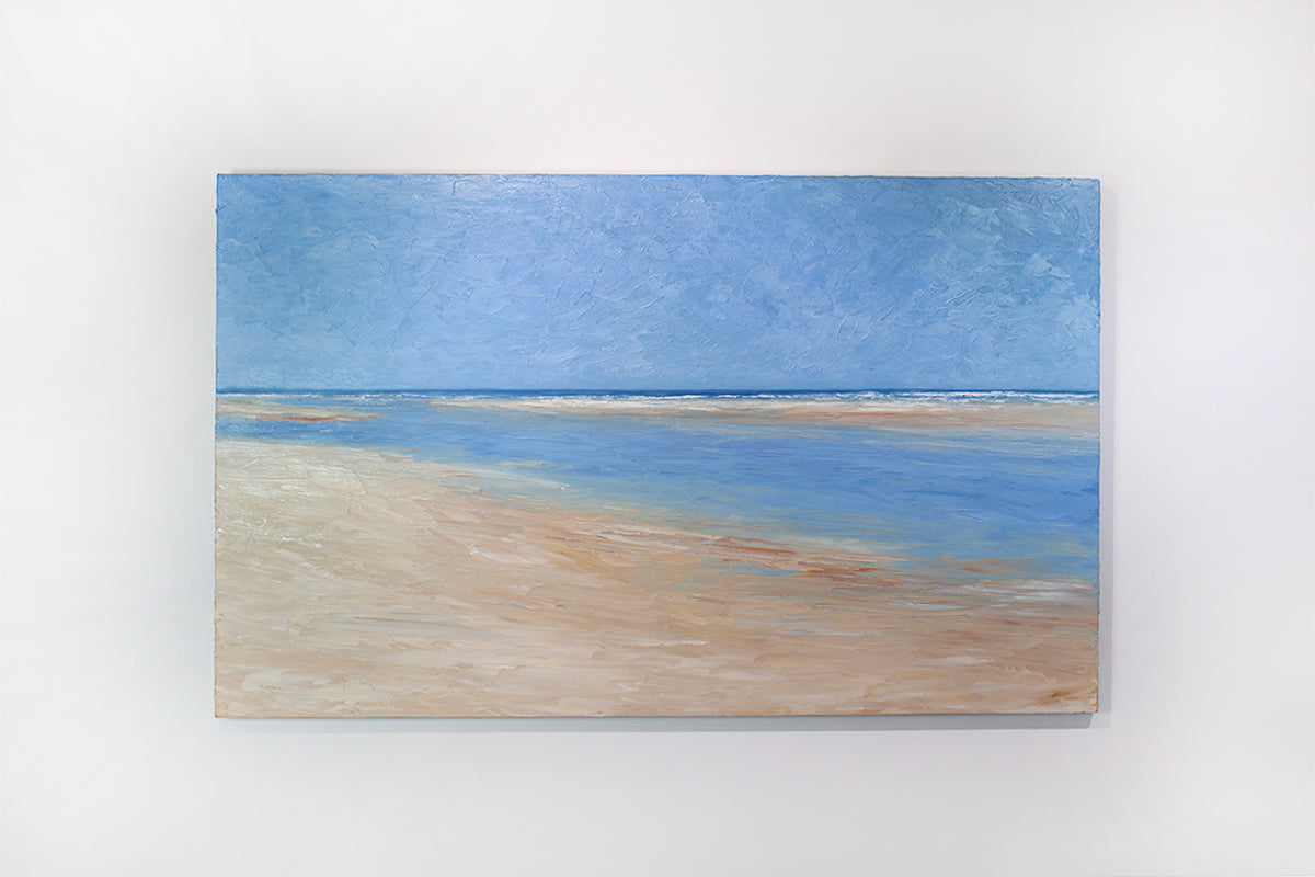 A textured blue and beige coastal painting of a beach hangs on a white wall. 