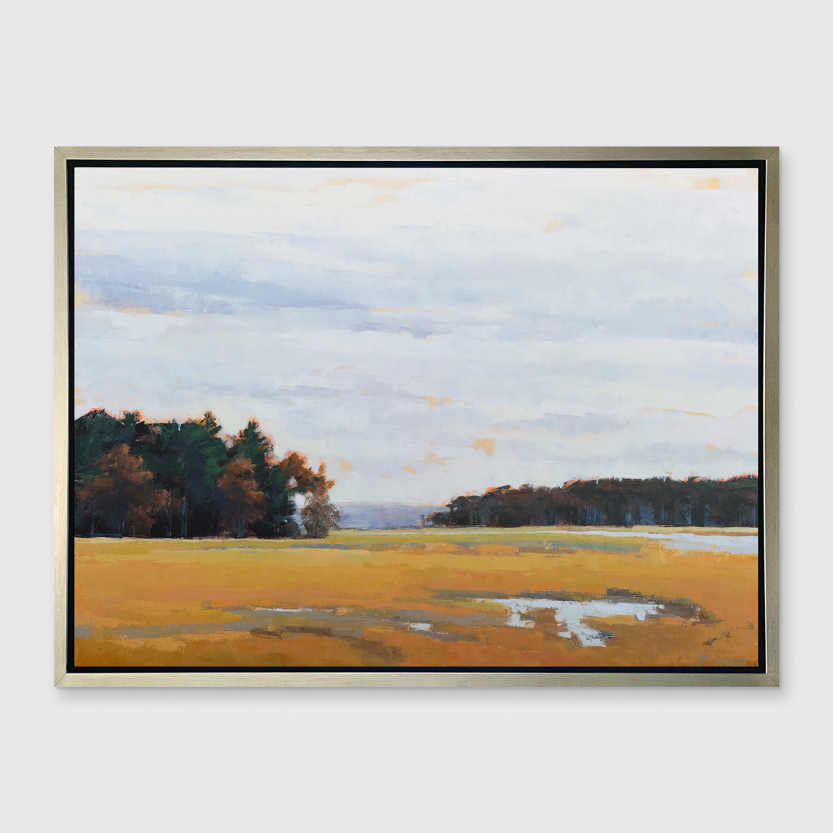 A landscape print in a silver floater frame hangs on a white wall.