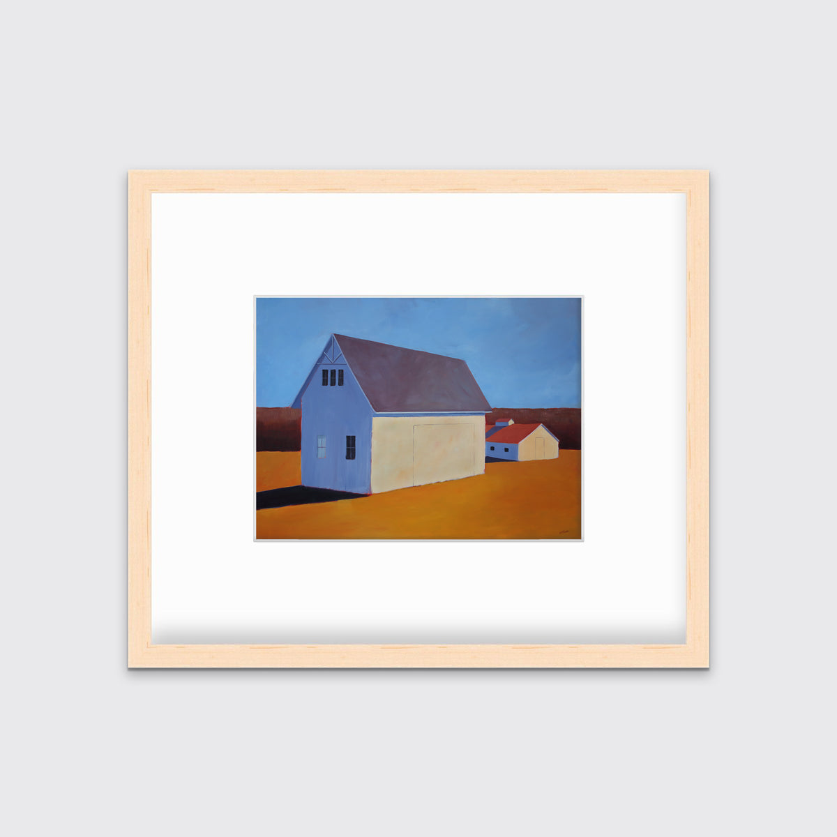 A blue and orange contemporary barn print in a natural wood frame with a mat hangs on a white wall.