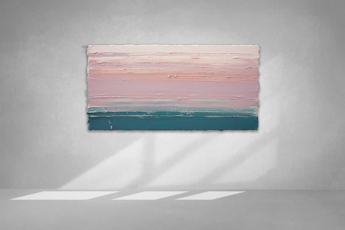 A peach, orange, coral, pale pink and teal thickly textured abstract painting hangs on a white wall with sunlight cascading over it.
