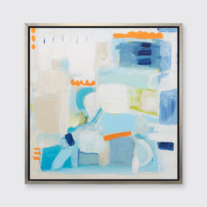 A blue, beige, white and orange abstract print in a silver floater frame hangs on a white wall.