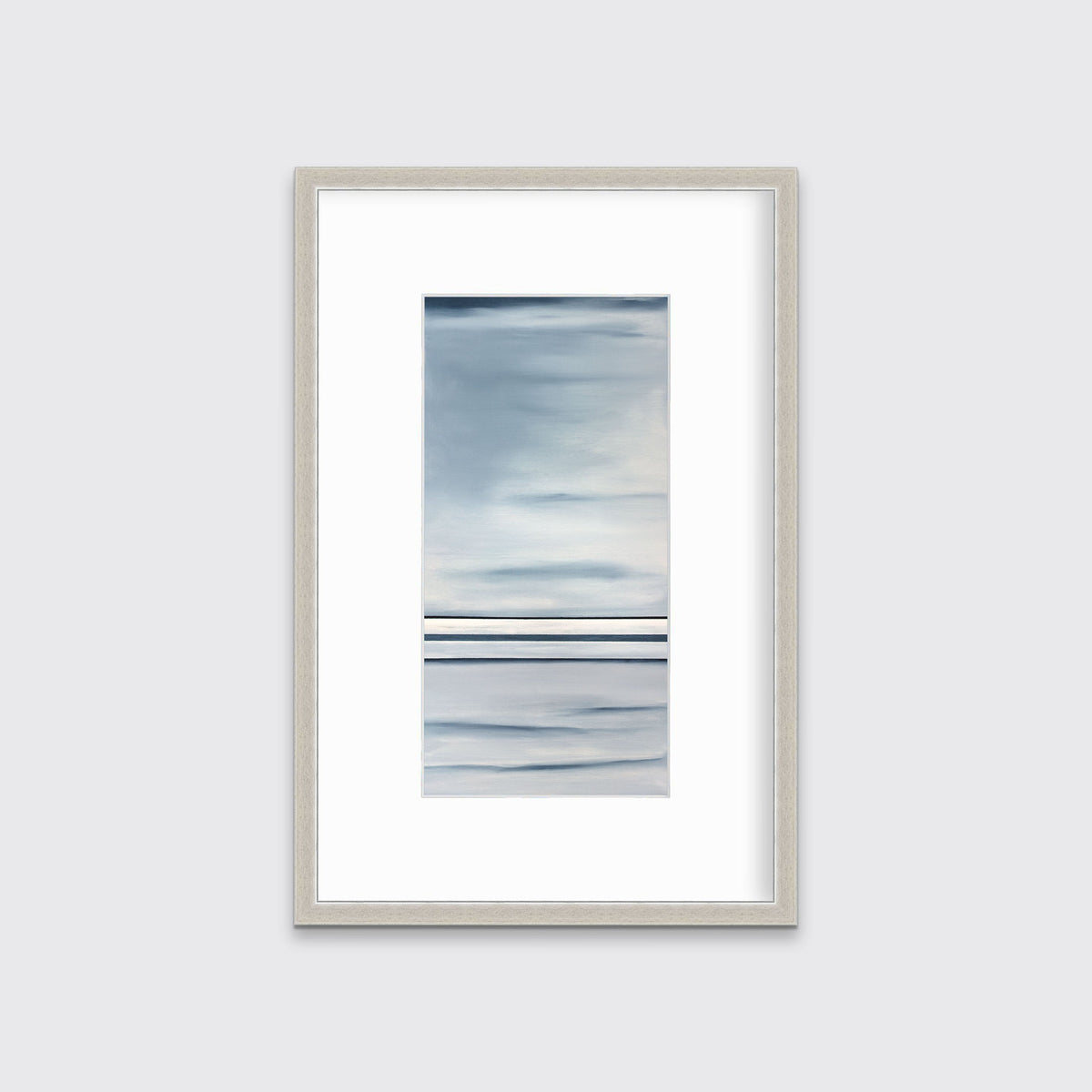 Blue and white abstract print in a silver frame with a mat hangs on a white wall.