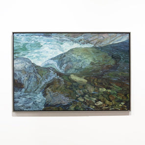 A framed painting of river water running over rocks hangs on a white wall.