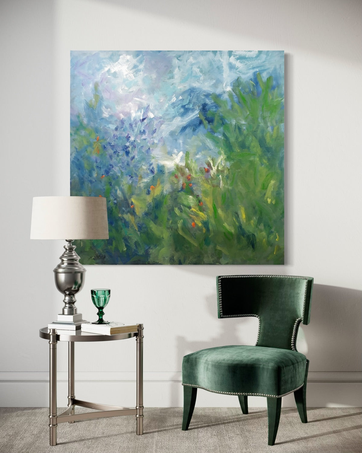 Modern interior with a green chair, side table, and abstract floral painting on the wall.
