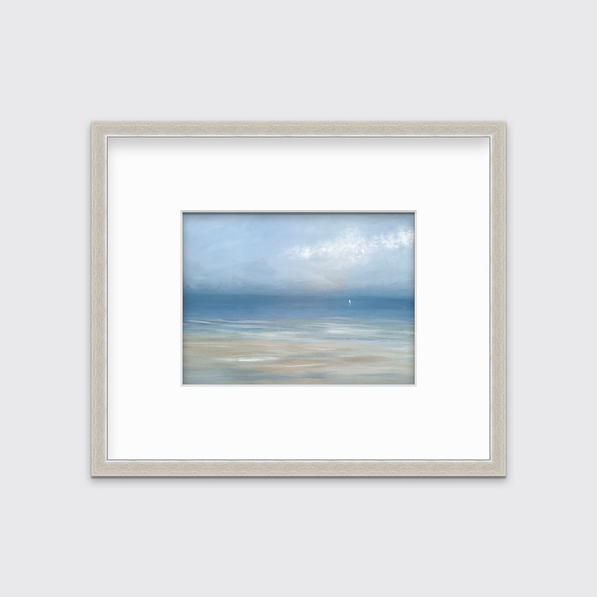 A light blue, white and beige abstract seascape print in a silver frame with a mat hangs on a white wall.