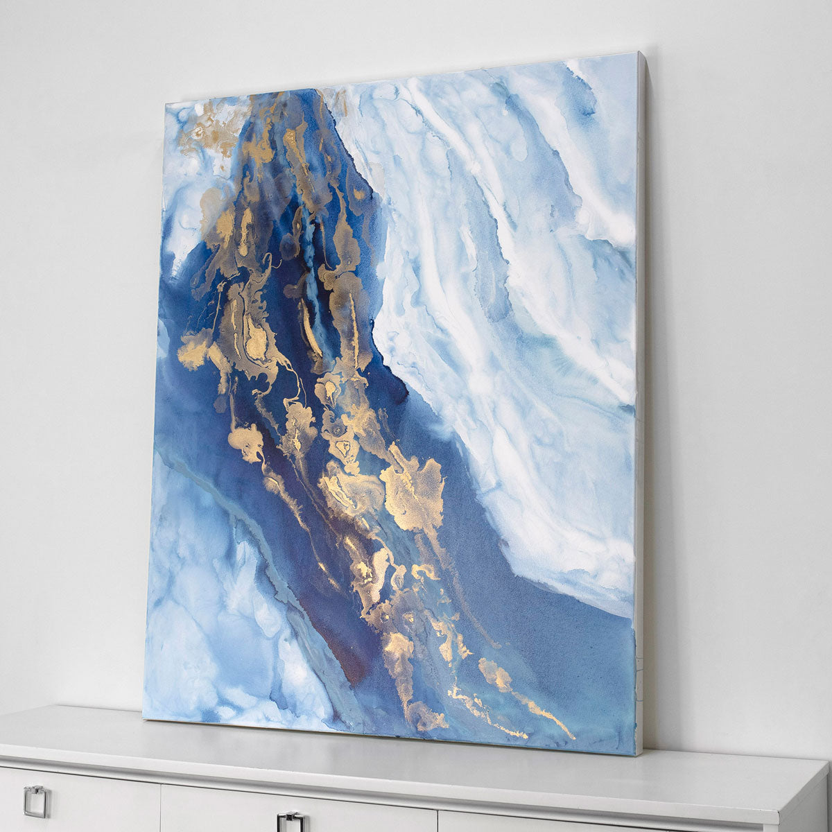 Abstract art painting with blue and gold tones on a white wall