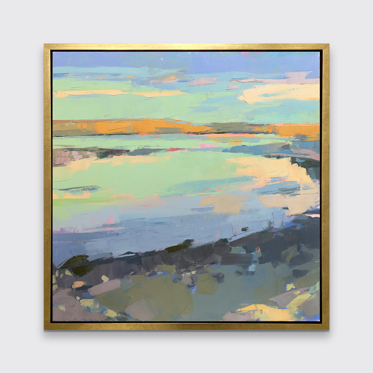A colorful abstract landscape print framed in a gold frame hangs on a white wall.