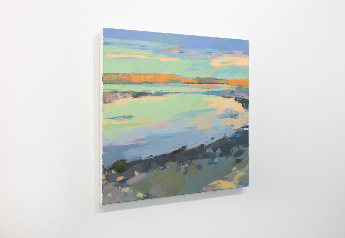 A pink, green, and blue abstract coastal landscape painting hangs on a white wall.