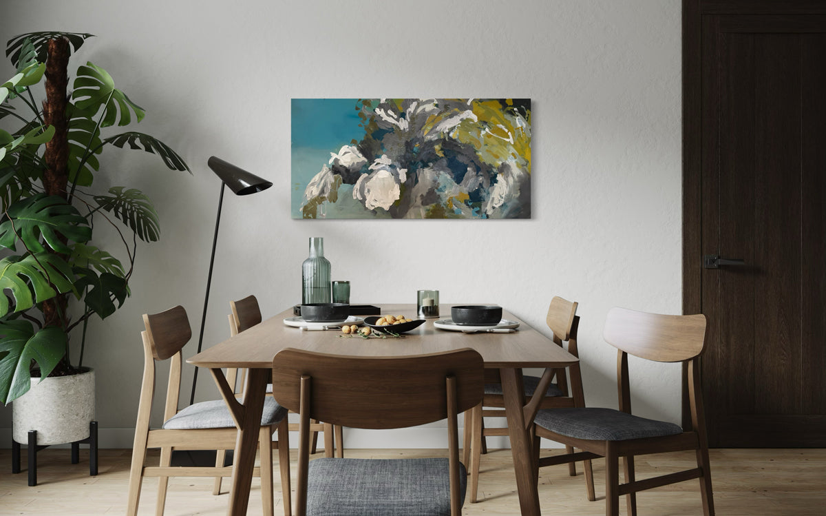 Dining room with a wooden table and chairs, abstract painting on the wall, and plants.