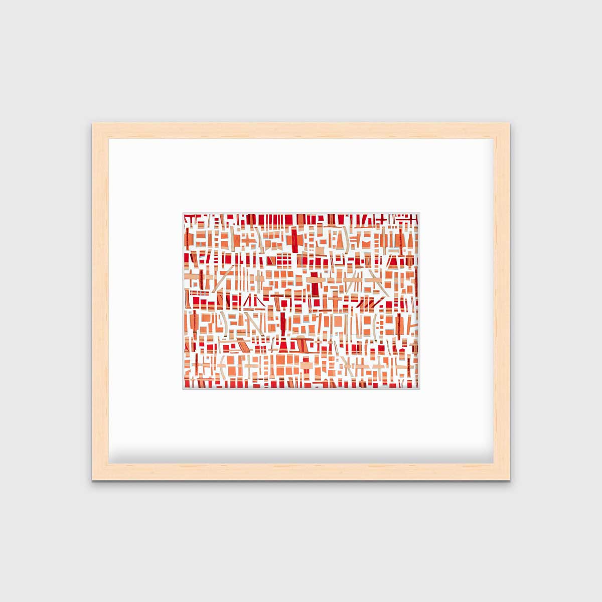 A red, white and orange abstract print in a natural wood frame with a mat hangs on a white wall.