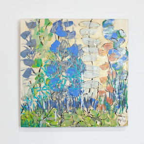 A green and blue abstracted encaustic floral painting hangs on a white wall.