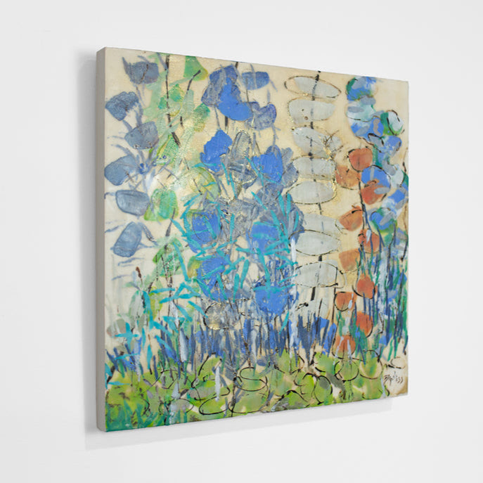 A green and blue abstracted encaustic floral painting hangs on a white wall.