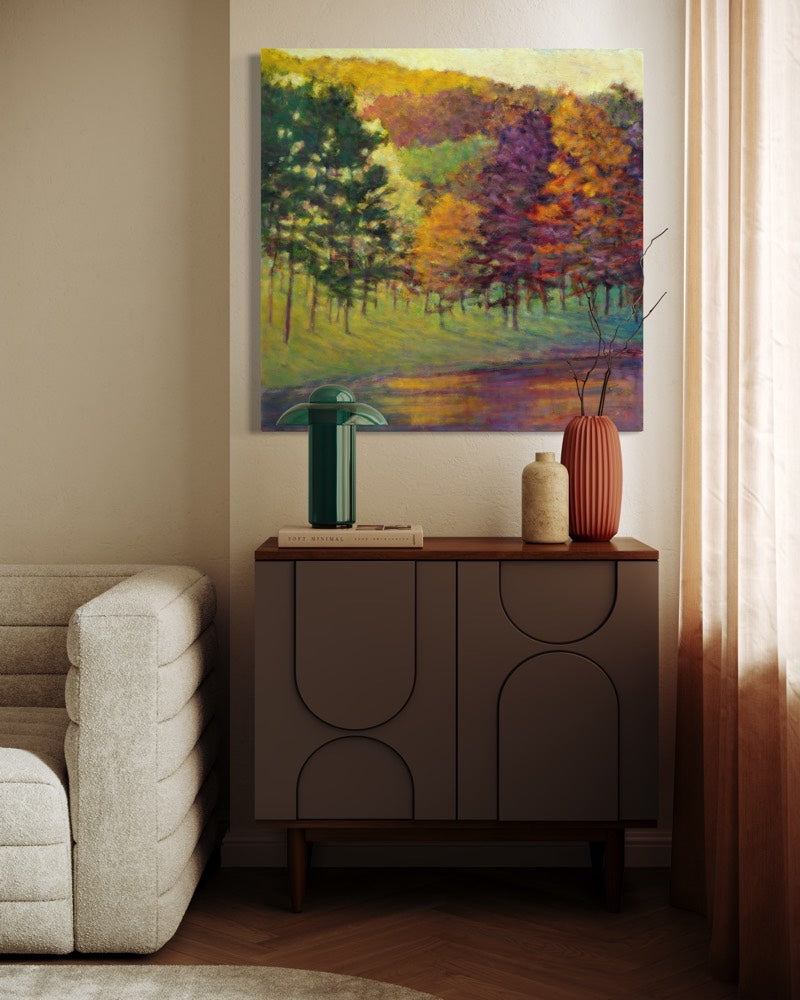 Room interior with a painting of a forest scene above a wooden cabinet.