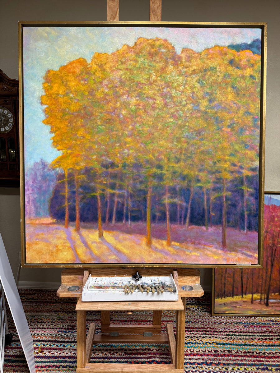 Framed painting of a forest scene with vibrant colors on an easel.