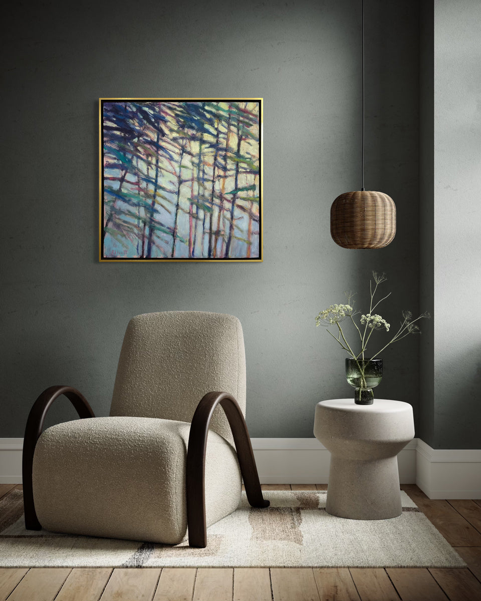 Modern interior with a beige armchair, abstract painting, and small table with a plant.