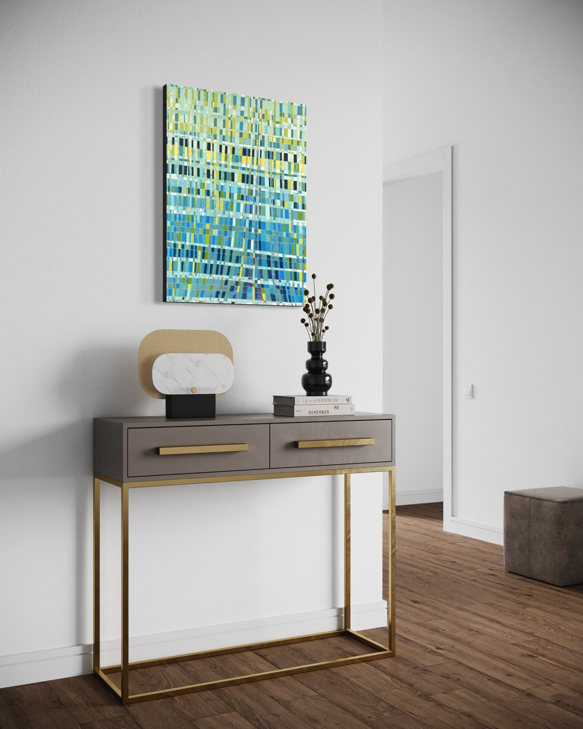 A modern console table with a gray top, gold metal frame, and gold handles, styled in a minimalist room with a colorful abstract painting on the wall above it.