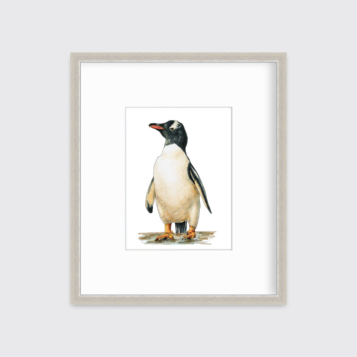 A penguin print in a silver frame with a mat hangs on a white wall.