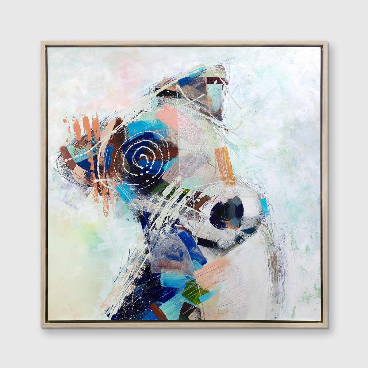 A multicolored abstract dog print in a white oak wood floater frame hangs on a white wall.