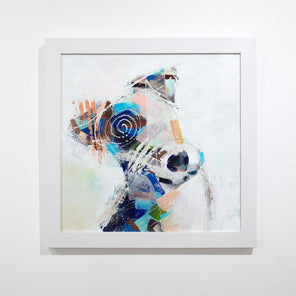 An abstracted painting of a dog framed in a white frame hangs on a white wall. 