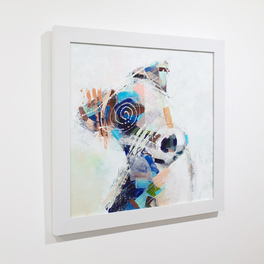 An abstracted painting of a dog framed in a white frame hangs on a white wall.