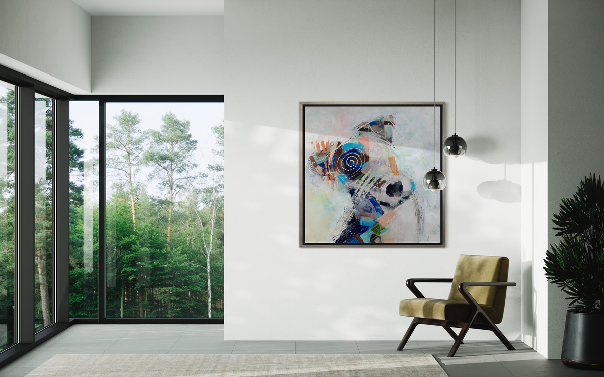A multicolored abstract dog print in a silver floater frame hangs on a white wall above a chartreuse and black armchair.