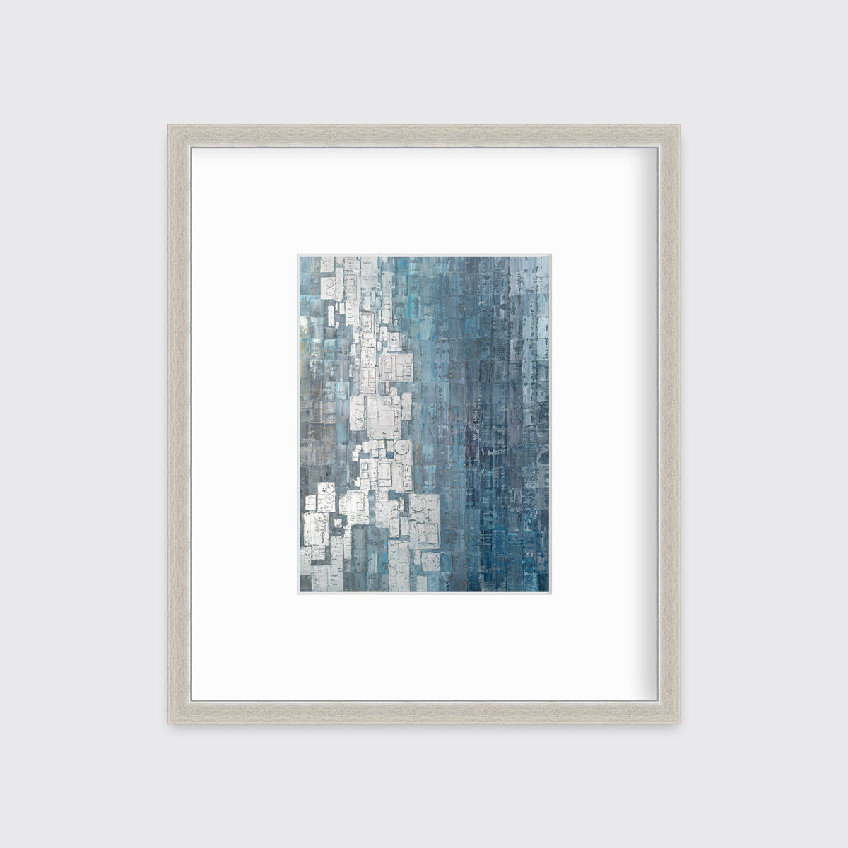 A blue, white and grey abstract print in a silver frame with a mat hangs on a white wall.