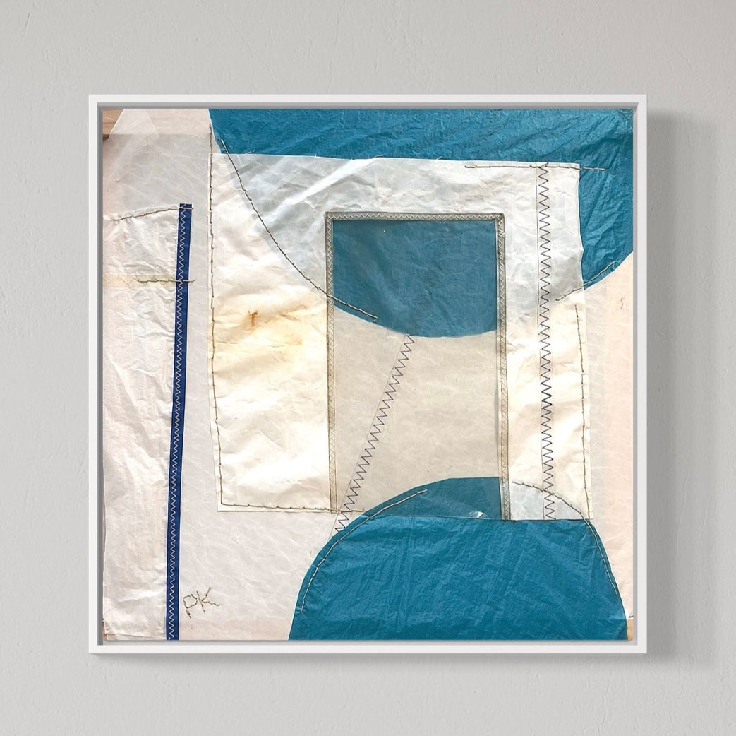 Framed abstract artwork featuring geometric patterns with blue and beige colors on a white background.