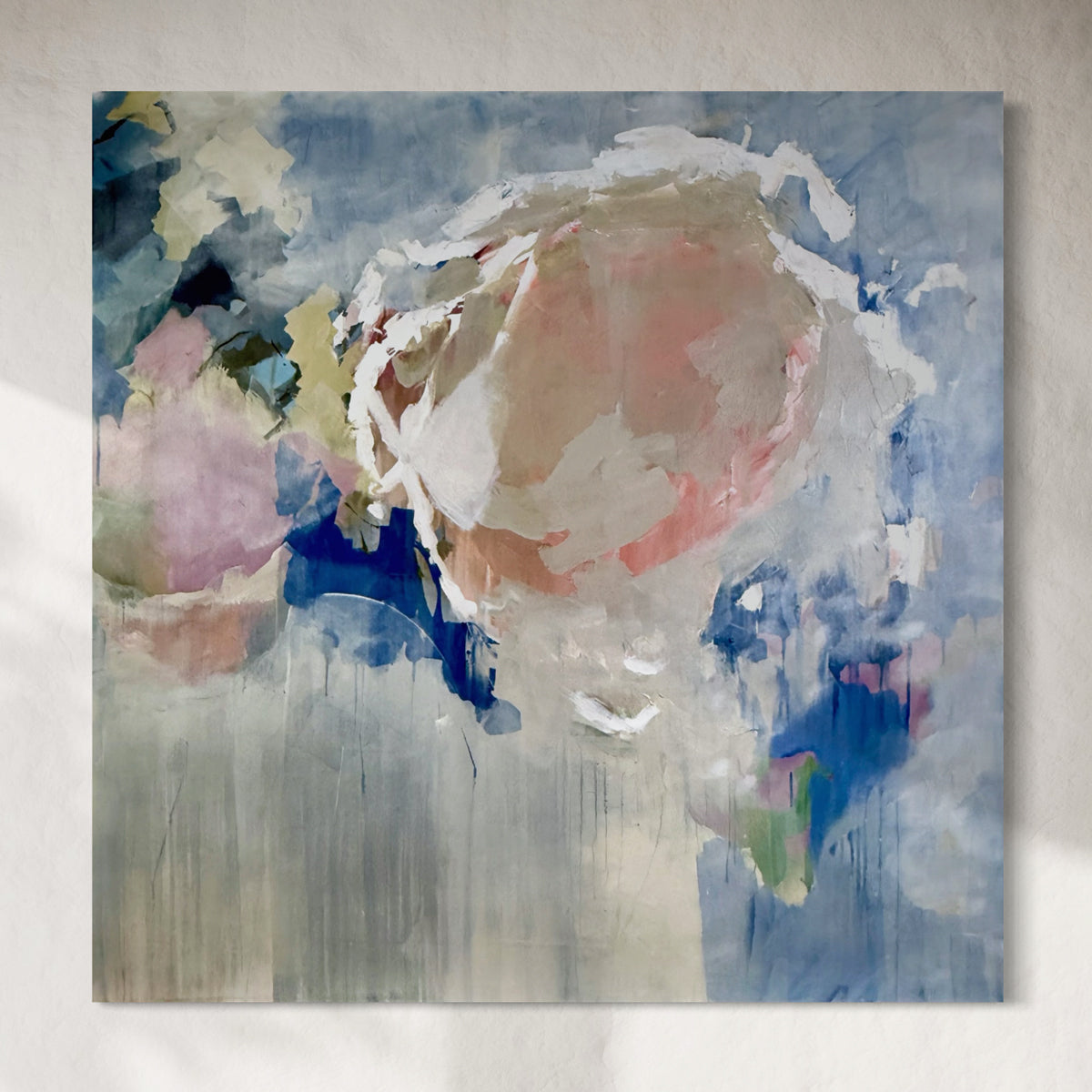 Abstract painting with soft pastel colors on a textured wall.