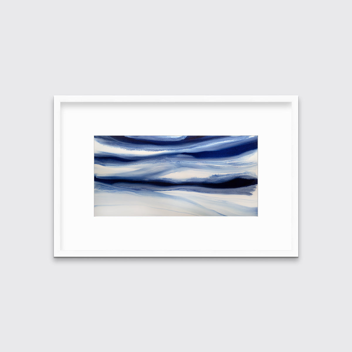 A dark blue and white abstract print in a white frame with a mat hangs on a white wall.