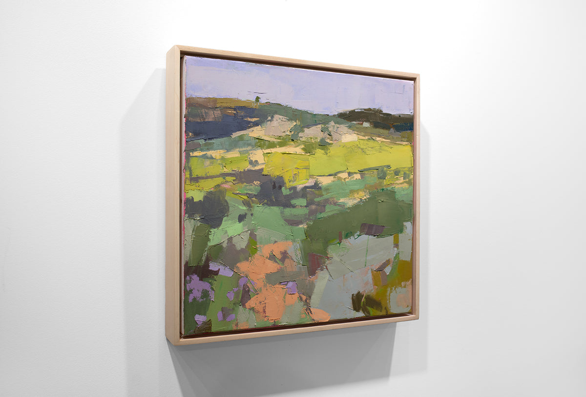 A textured abstract landscape painting hangs on a white wall.